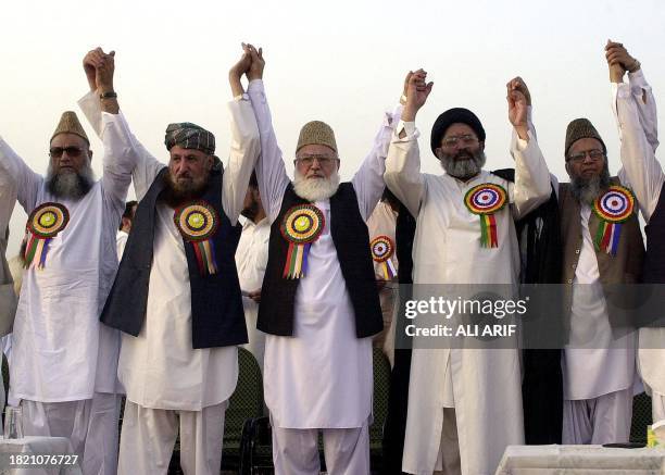 Qazi Hussain Ahmed , chief of Pakistan's fundamentalist party Jamaat-i-Islami , raises hand with other religious parties leaders during a grand...