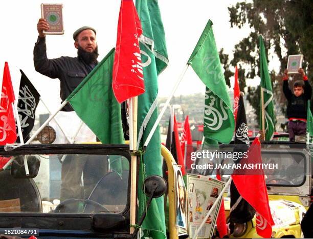 Supporters of the Islamic Resistance movement hold up copies of the Qoran during a rally in the West Bank refugee camp Jenin, 24 December. Several...