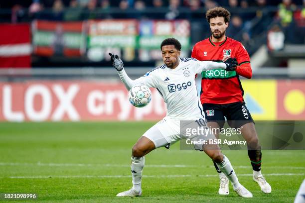 Chuba Akpom of AFC Ajax battles for possession with Philippe Sandler of NEC during the Dutch Eredivisie match between NEC Nijmegen and AFC Ajax at...