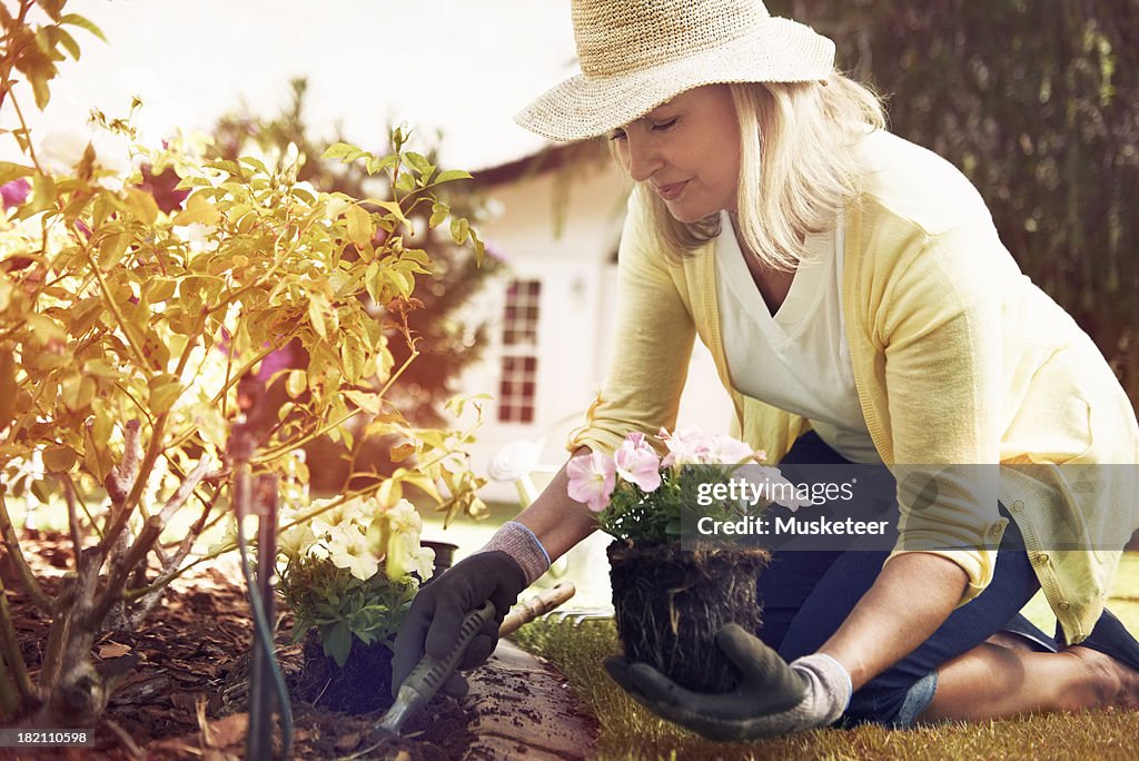 Woman planting flowers in her backyard