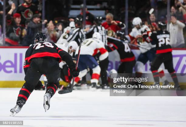 Travis Hamonic of the Ottawa Senators skates towards a scrum in the third period against the Florida Panthers at Canadian Tire Centre on November 27,...