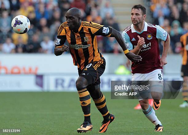 Hull City's Ivorian striker Yannick Sagbo tackles West Ham United's Romanian defender Razvan Rat during the English Premier League football match...
