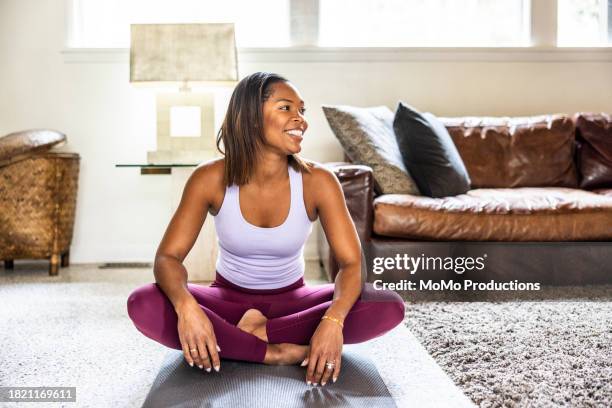 mother stretching and exercising at home - cross legged stock pictures, royalty-free photos & images