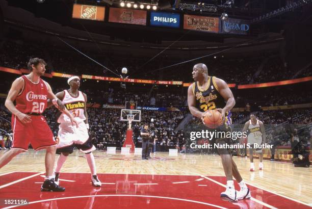 Former Los Angeles Laker Magic Johnson moves to the hoop during the NBA 2003 ALL-STAR Weekend Jeep ALL-STAR "Hoop It Up" Series at Philips Arena on...