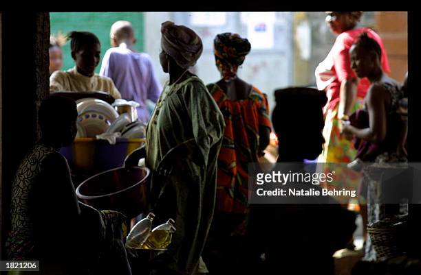 Sierra Leonian women buy and sell goods in a market February 7, 2003 in Freetown, Sierra Leone. Although recent reports show that Sierra Leone is...