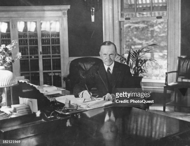 Portrait of American politician and US President Calvin Coolidge as he sits at his desk in the White House, Washington DC, August 15, 1923.