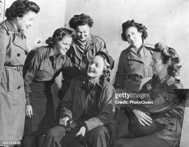 German-born American actress and singer Marlene Dietrich chats with a group of WACs at the headquarters of the 12th Army Group during a tour for...