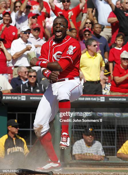 Brandon Phillips of the Cincinnati Reds celebrates at home plate after scoring against the Pittsburgh Pirates at Great American Ball Park on...