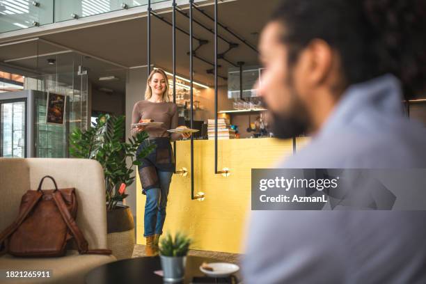 cheerful caucasian waitress serving a middle eastern customer - middle eastern food stockfoto's en -beelden