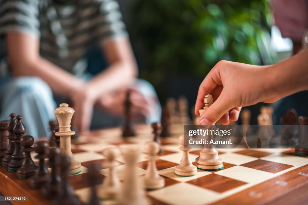 Famille joyeuse maîtrisant les échecs ensemble