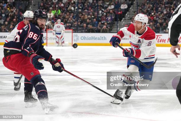Mike Matheson of the Montreal Canadiens passes the puck against Kirill Marchenko of the Columbus Blue Jackets during the first period at Nationwide...