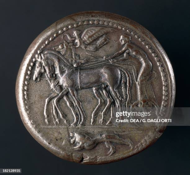 Silver Syracusan decadrachm depicting winged Victory on quadriga, verso. Commemorative coin minted to celebrate the victory of Gelo and the Syracusan...