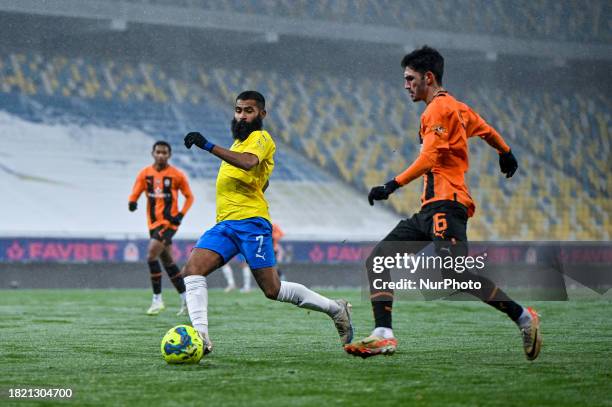 Defender Irakli Azarov of FC Shakhtar Donetsk is competing with midfielder Ari Moura of FC Metalist 1925 Kharkiv during the 2023/2024 Ukrainian...