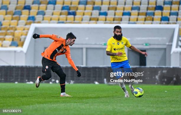 Defender Irakli Azarov of FC Shakhtar Donetsk is competing with midfielder Ari Moura of FC Metalist 1925 Kharkiv during the 2023/2024 Ukrainian...