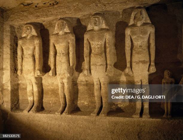 Statues of the deceased aligned in the burial chamber, Mastaba of Qar, Giza Necropolis . Egyptian Civilisation, Old Kingdom, Dynasty VI.