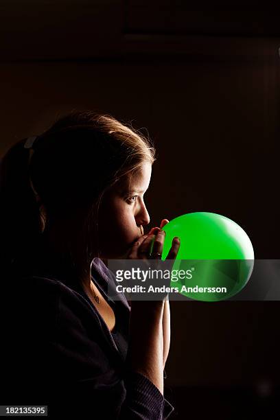 woman inflating ballon - inflar fotografías e imágenes de stock