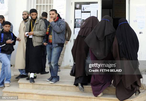 Female students, wearing niqab, walk up stairs at the office of the dean of the Faculty of Arts in Manuba, some 25 kms west of Tunis, on December 8,...
