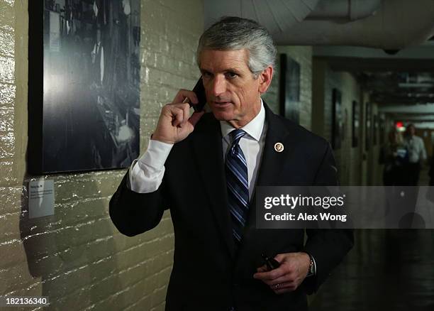 Rep. Scott Rigell talks on his phone as he arrives at a House Republican Conference meeting September 28, 2013 on Capitol Hill in Washington, DC. The...