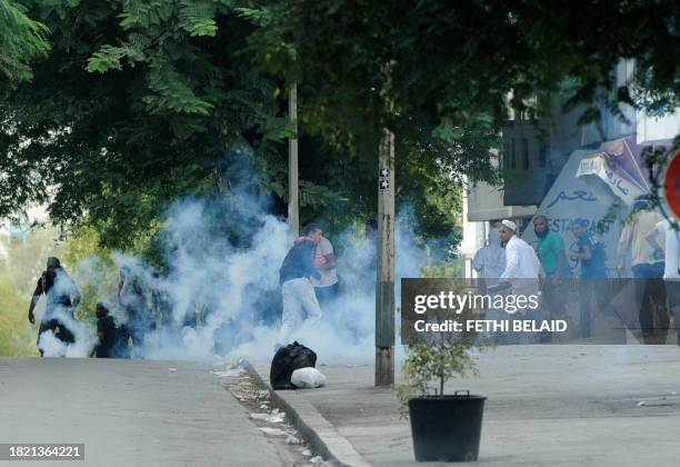 Demonstrators, mainly conservative Muslim Salafists, react as security forces launch tear during a demonstration against a private television station...