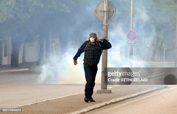 Masked demonstrator, reacts as security forces launch tear during a demonstration with mainly conservative Muslim Salafists against a private...