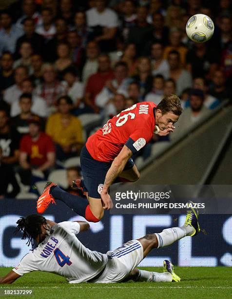 Lille's French forward Nolan Roux is tackled by Lyon's Burkinabe defender Bakary Kone during a French L1 football match between Lyon and Lille on...