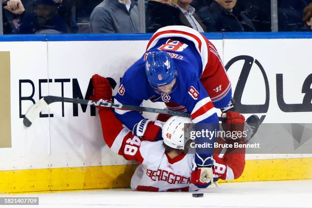 Jacob Trouba of the New York Rangers checks Jonatan Berggren of the Detroit Red Wings during the second period at Madison Square Garden on November...