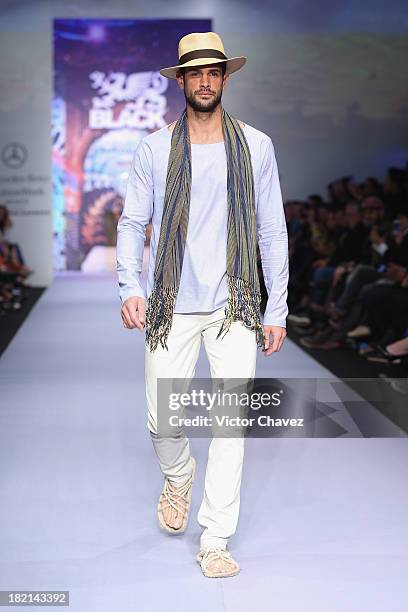 Model walks the runway at the Black Spring/Summer 2014 collection during the third day of Mercedes-Benz Fashion Week Mexico at Campo Marte on...