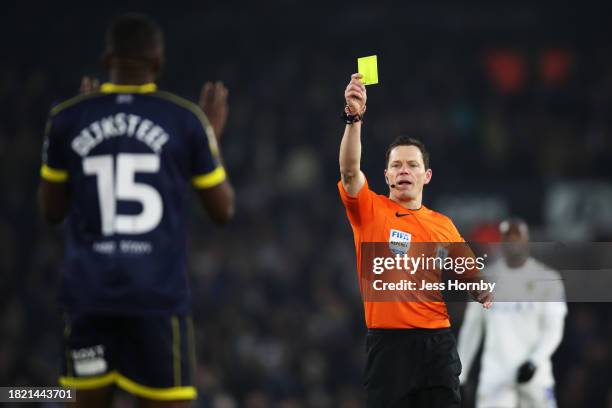 Referee Darren England shows a yellow card to Anfernee Dijksteel of Middlesbrough during the Sky Bet Championship match between Leeds United and...