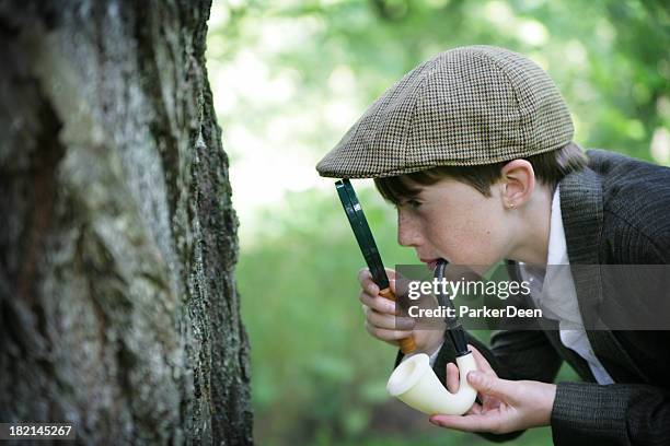 enfant habillé comme sherlock holmes utilise une loupe dans la nature - sherlock holmes photos et images de collection