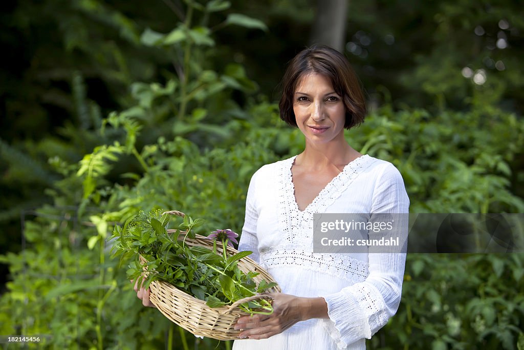 Frau Gärtner holding Korb mit Kräutern