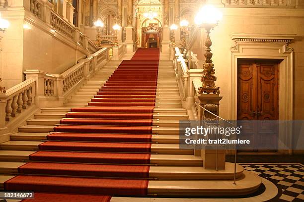 red carpet cascading down a grand staircase - red carpet event stockfoto's en -beelden