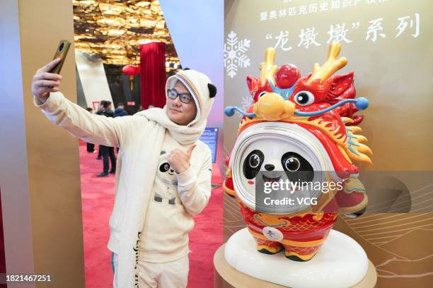 Olympic mascot souvenir collector Zhang Wenquan takes a selfie with Chinese zodiac dragon version of Beijing Winter Olympic Games mascot Bing Dwen...