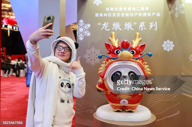 Olympic souvenir collector Zhang Wenquan takes a selfie with Chinese zodiac dragon version of Beijing Winter Olympic Games mascot Bing Dwen Dwen at...