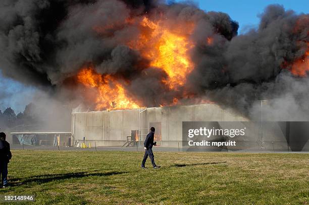 warehouse on fire releasing think black smoke to the sky - smoke rubble stock pictures, royalty-free photos & images