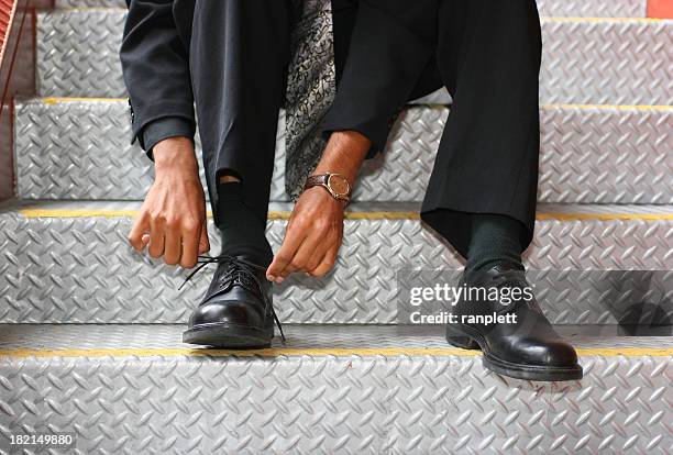 businessman tying his shoes - metallic suit stock pictures, royalty-free photos & images