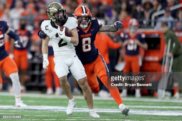 Taylor Morin of the Wake Forest Demon Deacons is tackled by Justin Barron of the Syracuse Orange during the fourth quarter at JMA Wireless Dome on...