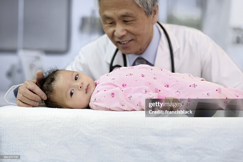 Maschio medico esaminando il bambino asiatico
