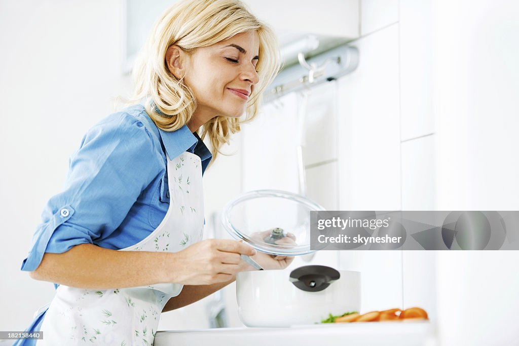 Beautiful blonde woman cooking in the kitchen