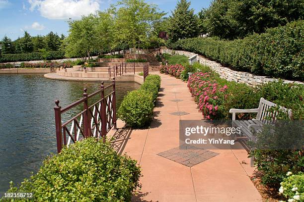 urban park with walking path, landscaping by lake in spring - minneapolis neighborhood stock pictures, royalty-free photos & images