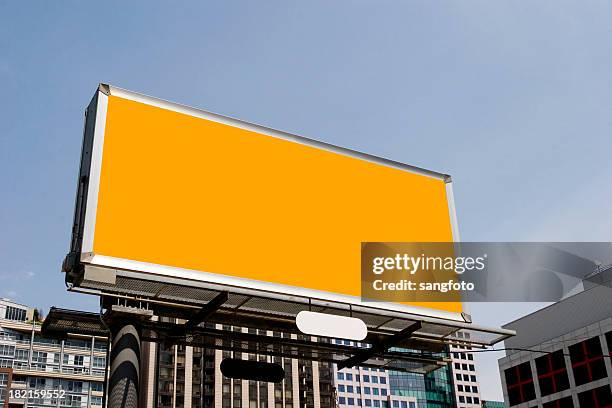 plain orange billboard amongst office buildings - building billboard stock pictures, royalty-free photos & images