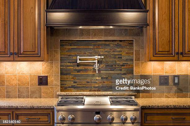 stainless residential kitchen range with pot faucet, tile & cabinets - gas stove burner stockfoto's en -beelden