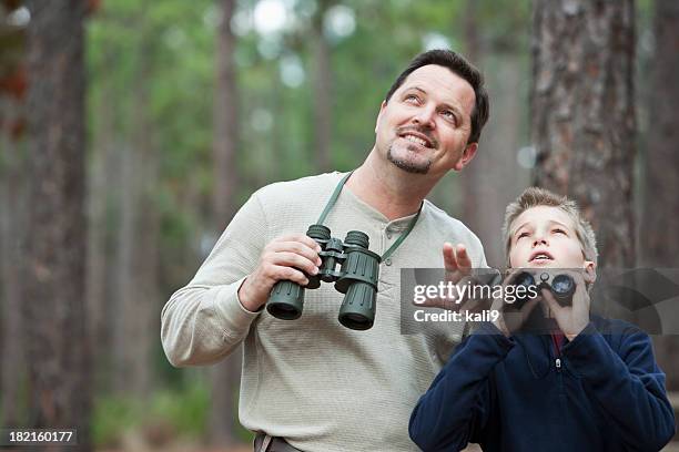 father and son enjoying scenic view with binoculars - bird watching stock pictures, royalty-free photos & images