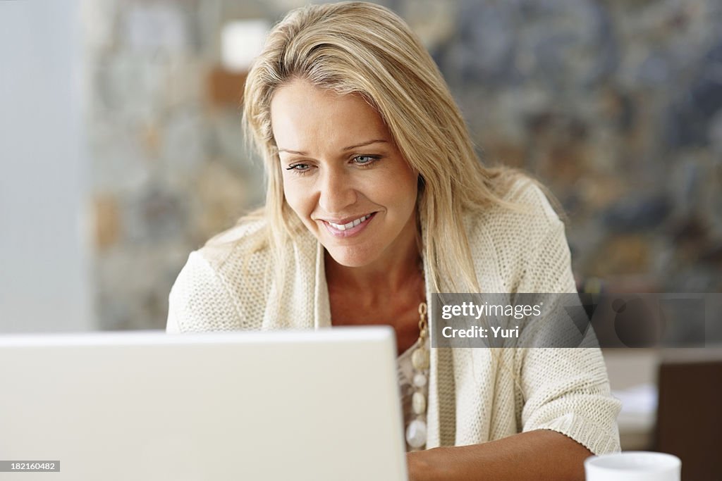 Feliz mulher de meia idade com um computador portátil