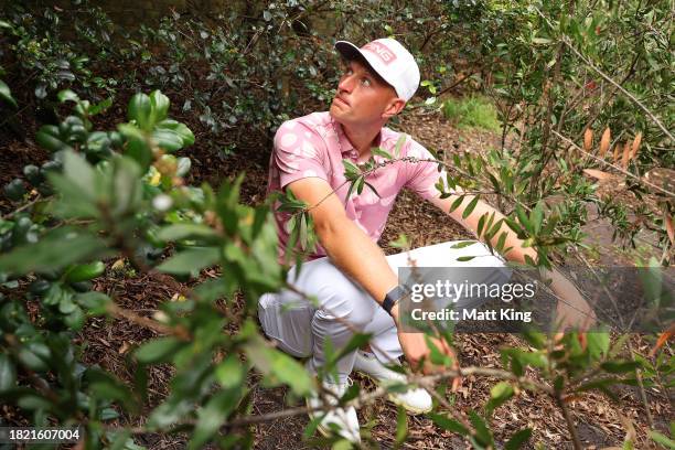 Adrian Meronk of Poland inspects his ball in the heavy rough on the 13th hole during the ISPS HANDA Australian Open at The Australian Golf Course on...