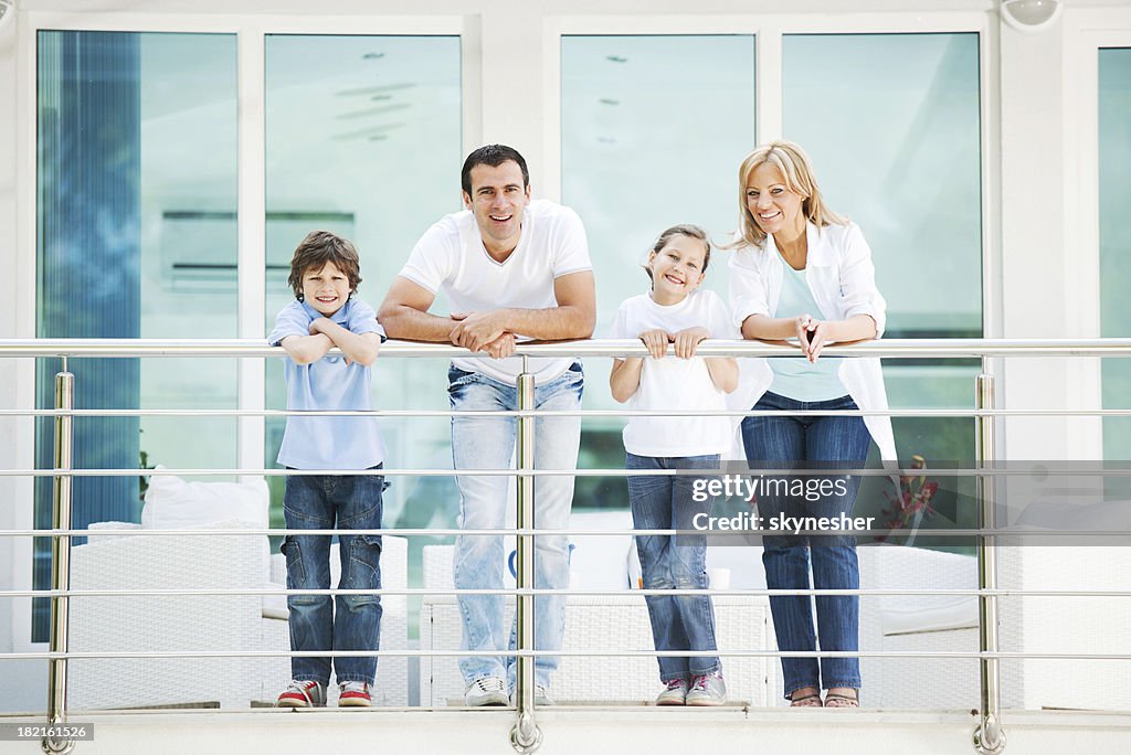 Happy family standing on the balcony.