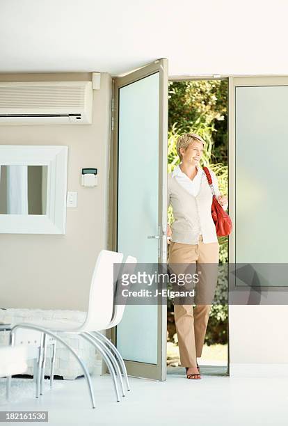 woman entering her house through the door - alarm system stock pictures, royalty-free photos & images