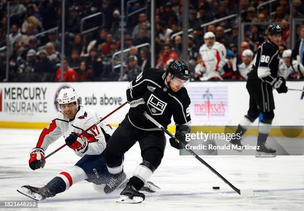 Carl Grundstrom of the Los Angeles Kings steals the puck from Dylan Strome of the Washington Capitals in the second period at Crypto.com Arena on...