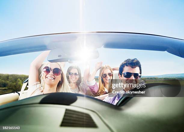 grupo de jóvenes disfrutar de un paseo en coche descapotable. - four people in car fotografías e imágenes de stock