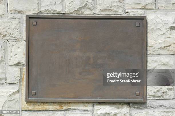 bronze memorial plaque on stone wall - bronskleurig stockfoto's en -beelden