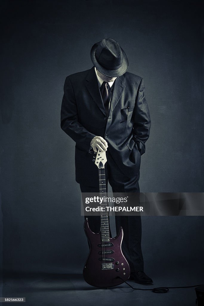 Elegant senior with an electric guitar